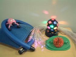 a photograph of a collection of vibrating and light-up toys.  There is also a koosh ball switch toy.